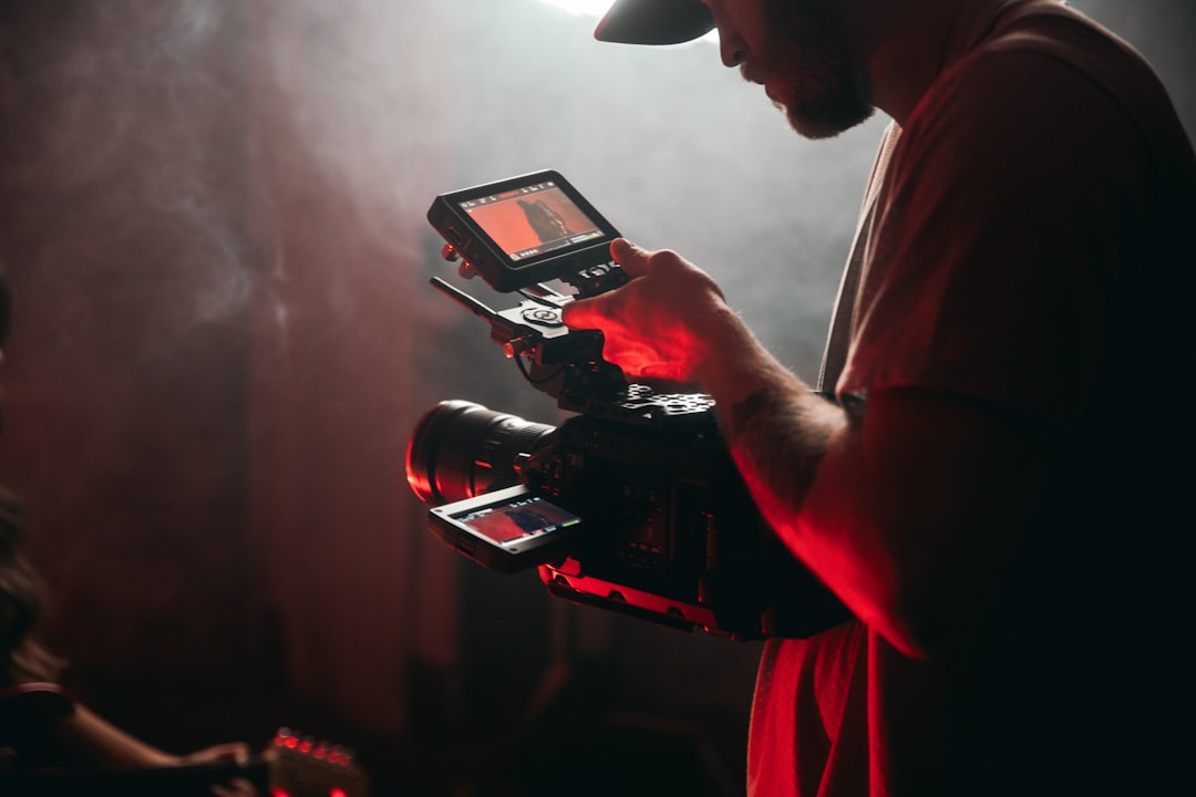 man-in-white-t-shirt-holding-black-video-camera-dqmxihyx5ue
