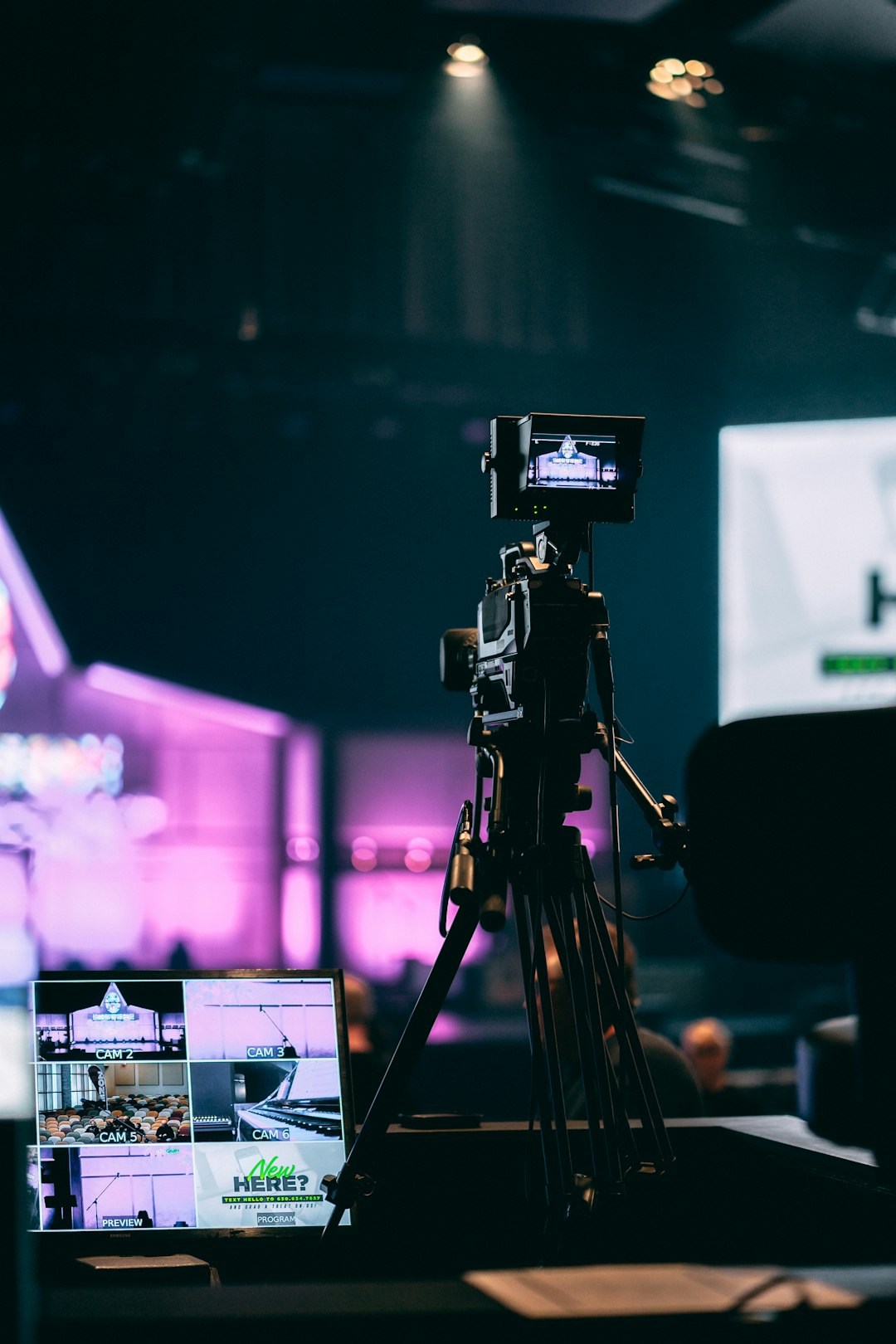 selective-photo-of-camera-with-tripod-and-laptop-computer-turned-on-8xzrrb54lgg